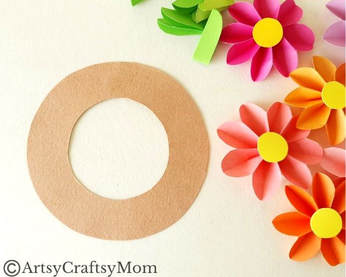 Spruce up your room or living space with this pretty paper flower wreath craft! It's easy enough for kids to make, and all you need is craft paper!