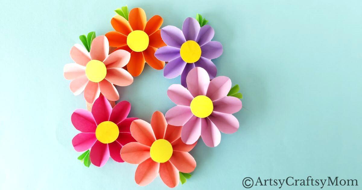 Spruce up your room or living space with this pretty paper flower wreath craft! It's easy enough for kids to make, and all you need is craft paper!