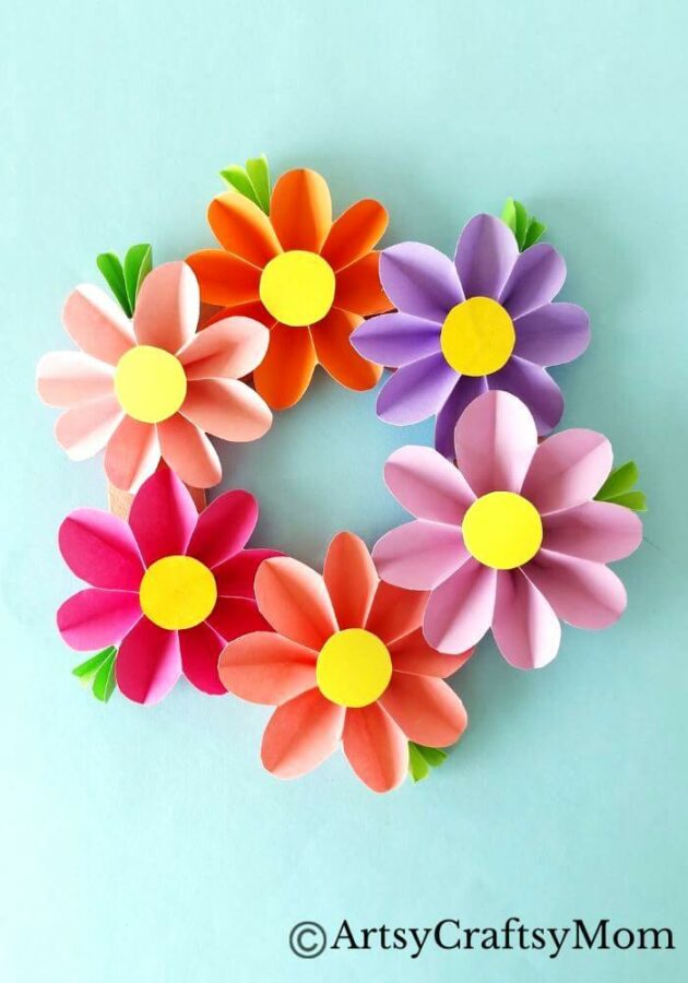 Spruce up your room or living space with this pretty paper flower wreath craft! It's easy enough for kids to make, and all you need is craft paper!