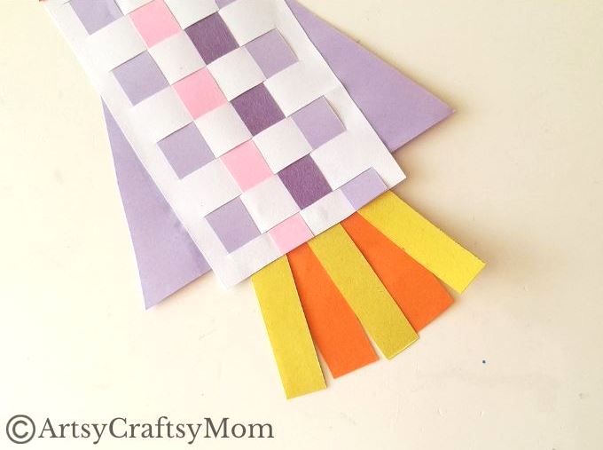 New to paper weaving? This colorful woven paper rocket craft is the perfect choice for little kids starting out, without overwhelming them!